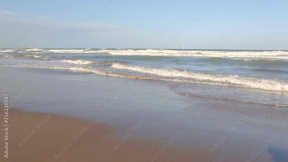 Yacht with a white sail stands in the sea. Tourists ride off the coast. A walk in and out in the sea on a sunny day Yacht with a white sail stands in the sea. Tourists ride off the coast. A walk in and out in the sea on a sunny day