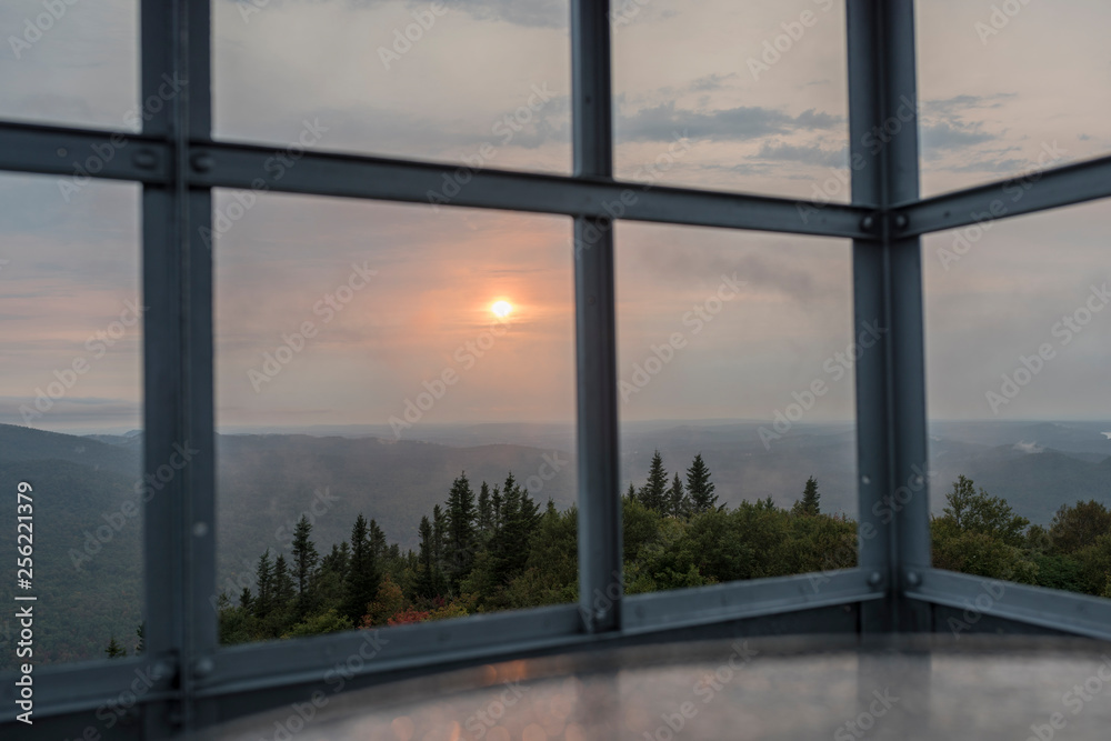 Naklejka premium abandoned fire tower during sunset with low lying wispy clouds
