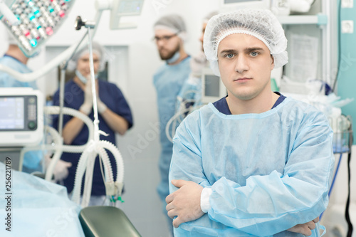 Professional surgeon at the operating theatre medical team on the background