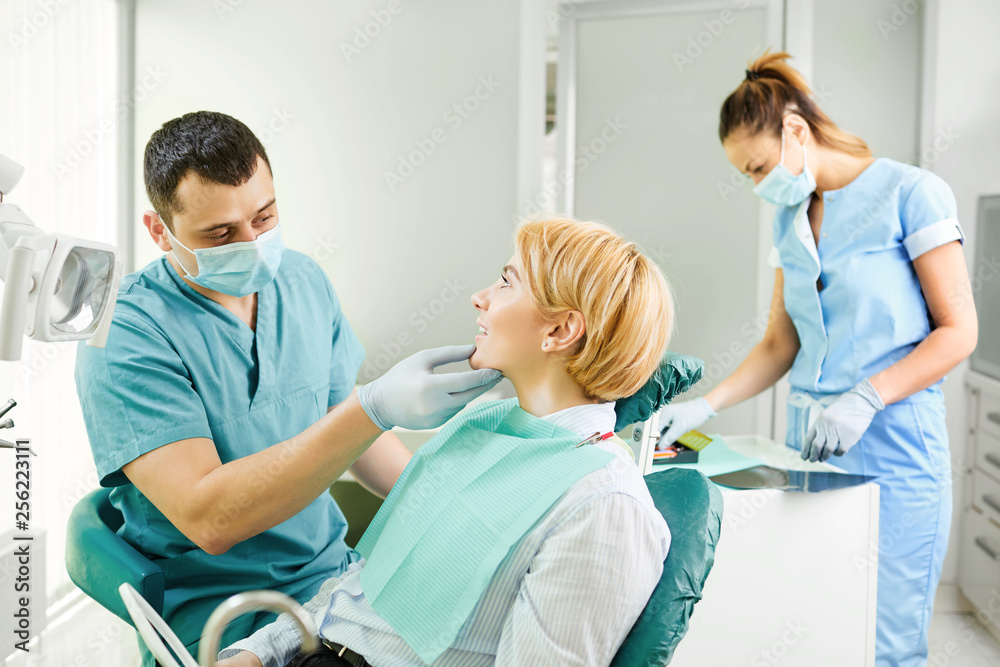 Fototapeta premium Dentist examines the teeth of the patient girl
