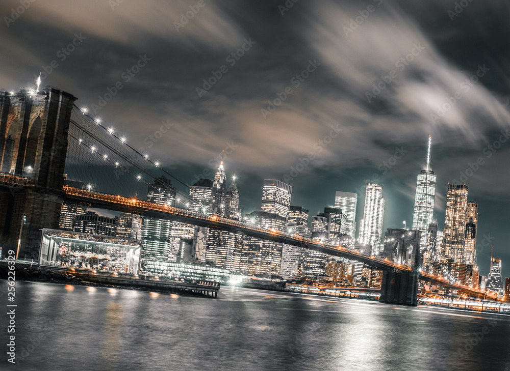 long exposure wispy clouds dominate the brooklyn bridge and downtown Manhattan