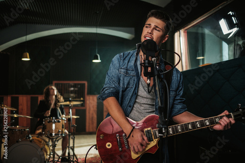 Music band having rehearsal in a studio