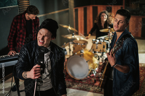 Fotografie Music band having rehearsal in a studio