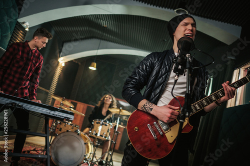 Music band having rehearsal in a studio