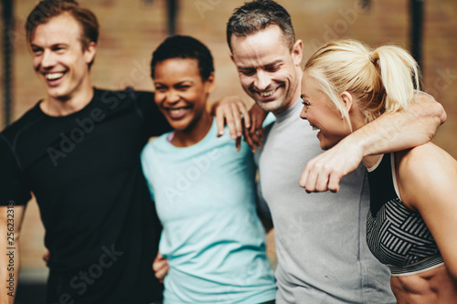 Friends laughing after a workout together in a gym