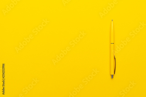 yeloow ballpoint pen on the yellow background with copy space photo