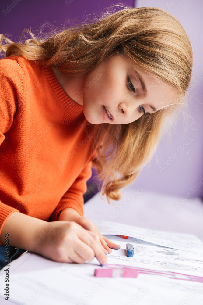 Cute little girl drawing in a coloring book Cute little girl drawing in a coloring book
