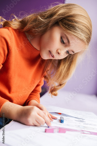 Cute little girl drawing in a coloring book