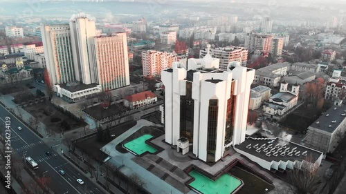 Aerial drone view of presidency building at sunrise. Warm sun, city and cars riding on background. Chisinau, Moldova photo