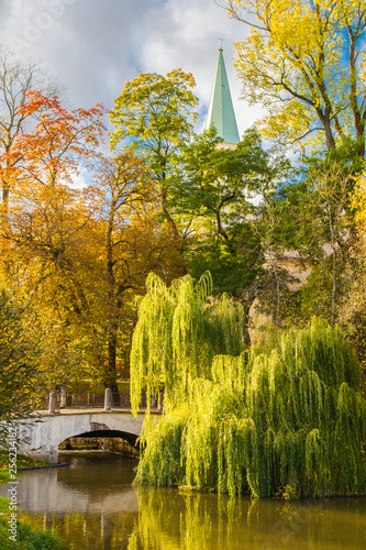 Beautiful autumn landscape with a bridge and a church in the background.