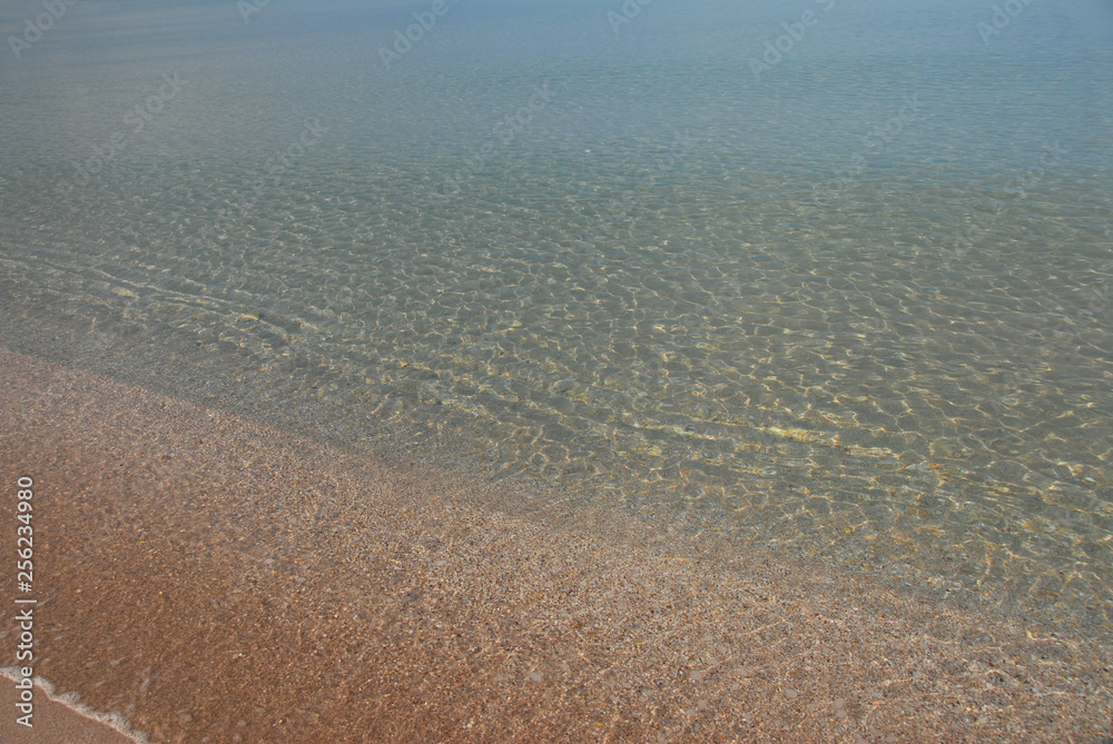 Fototapeta premium The quiet expanse of the sea, so well lit by sunlight, that the bottom is visible in shallow water. Very beautiful transition from light yellow sand to turquoise on the horizon.