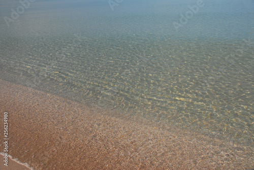 The quiet expanse of the sea  so well lit by sunlight  that the bottom is visible in shallow water. Very beautiful transition from light yellow sand to turquoise on the horizon.