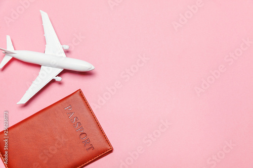 Travel by plane vacation summer weekend sea adventure trip journey ticket tour concept. Minimal simple flat lay with plane and passport on pink pastel trendy modern background. Tourist essentials