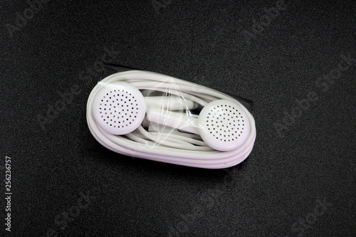 Earphone or earphones on black background.the white earphones for using digital music or smart phone | earbuds isolated. Top view