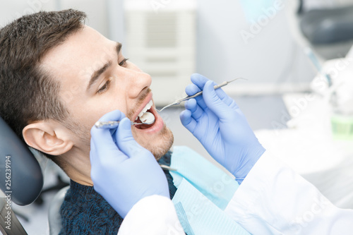 Young man visiting dentist at the clinic