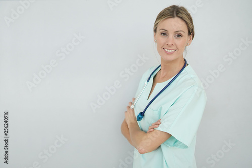 Smiling nurse looking at camera on grey background