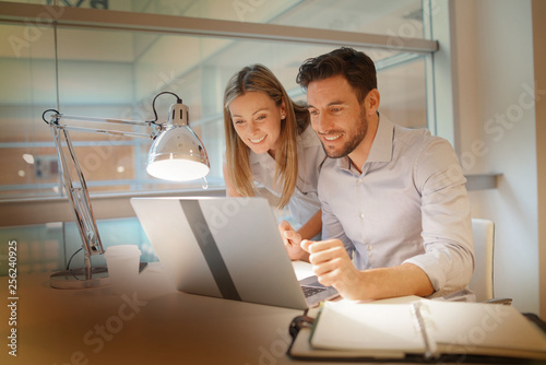 Male and female coworkers discussing ideas in modern office