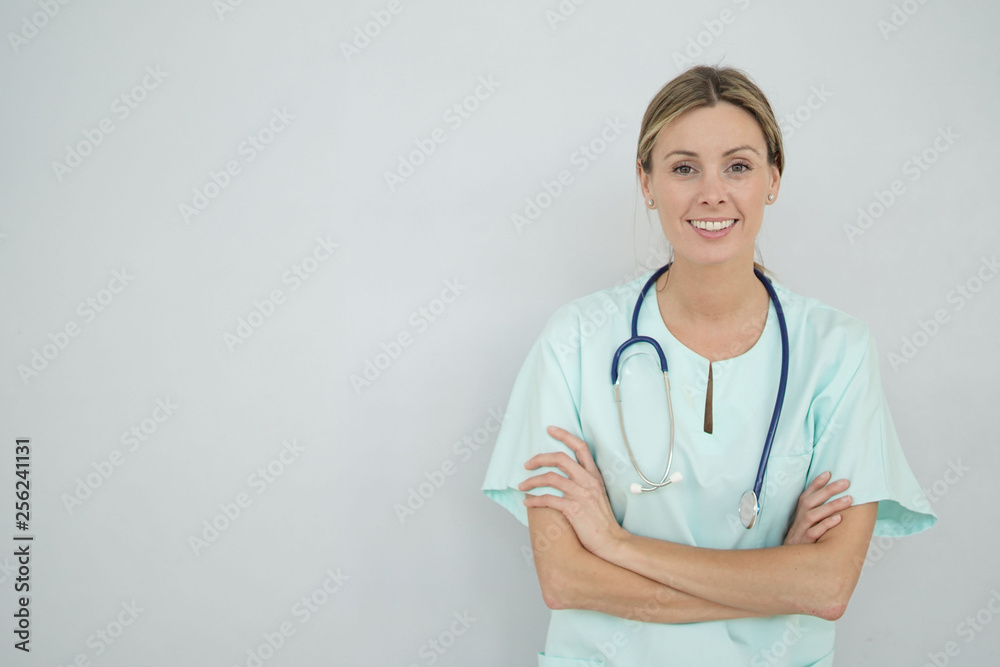 Smiling nurse looking at camera on grey background Smiling nurse looking at camera on grey background