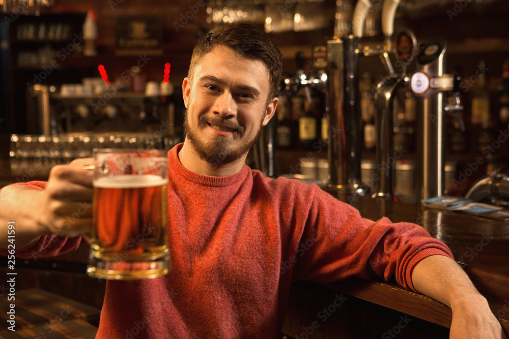 Young man relaxing at the pub having beer Young man relaxing at the pub having beer