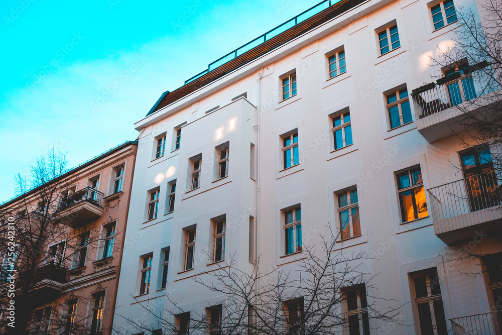 Naklejka premium white apartment house next to an brown building at berlin