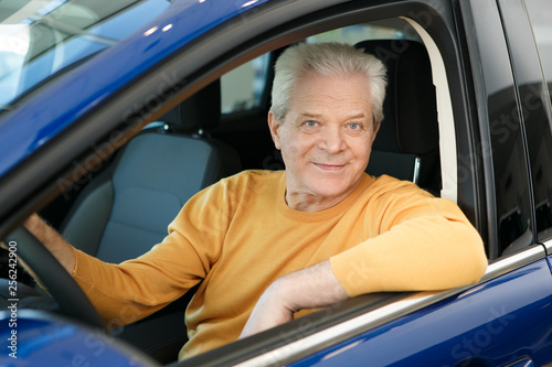 Senior man buying a new car at the dealership