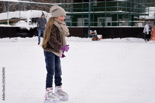 Young longhair girl wearing in casual winter clothing on ice rink