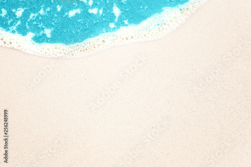 Beautiful tropical sea beach sand and surf texture background. Sea sand shore top view, summer holiday and vacation concept