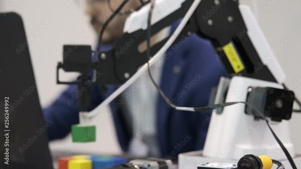 Robotic mechanism in action. Electronic engineer working in science research laboratory testing robotic program. Silhouette specialist scientist working in a modern computer program of the future Robotic mechanism in action. Electronic engineer working in science research laboratory testing robotic program. Silhouette specialist scientist working in a modern computer program of the future