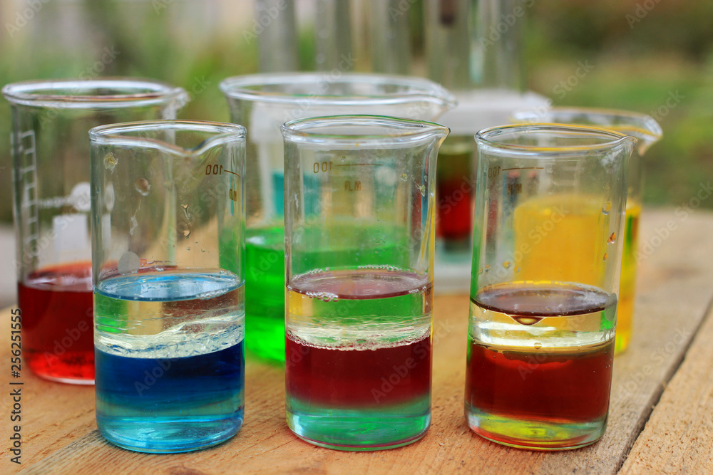 Multilayer colored substances are in three beakers. Multilayer colored substances are in three beakers.