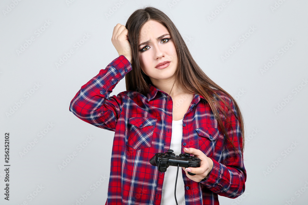 Beautiful girl with joystick on grey background Beautiful girl with joystick on grey background