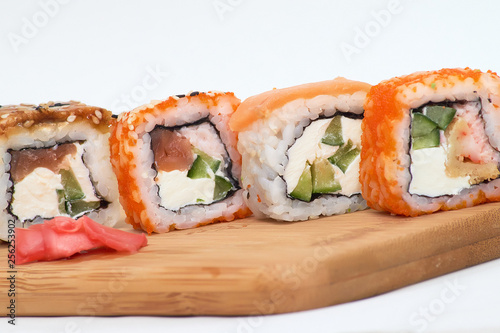 set of four sushi rolls on a wooden Board.