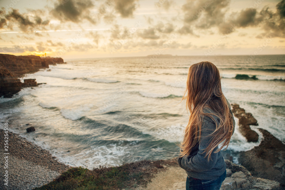 Side view of woman standing at beach during sunset Side view of woman standing at beach during sunset