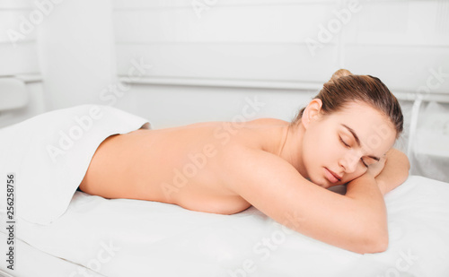 woman with perfect fresh skin lying on a massage table and relaxing. time for yourself in the spa salon