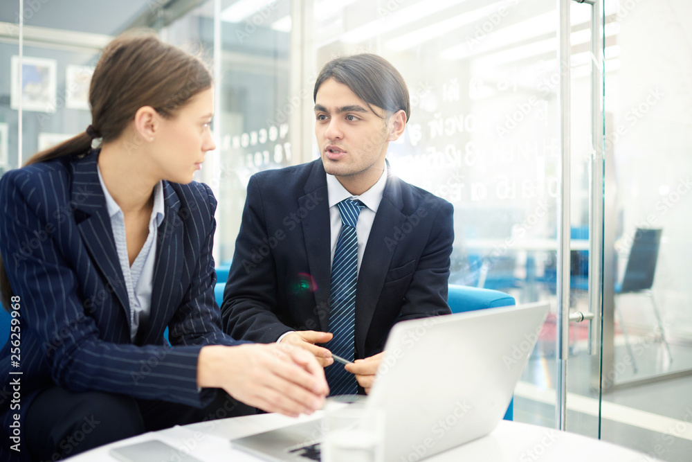 Portrait of two young business people talking in office while collaborating on startup project, copy space Portrait of two young business people talking in office while collaborating on startup project, copy space