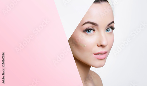 Portrait of young beautiful woman with healthy glow perfect smooth skin look into the hole of colored paper. Model with natural nude make up. Fashion, beauty, skincare, cosmetology concept. © KDdesignphoto