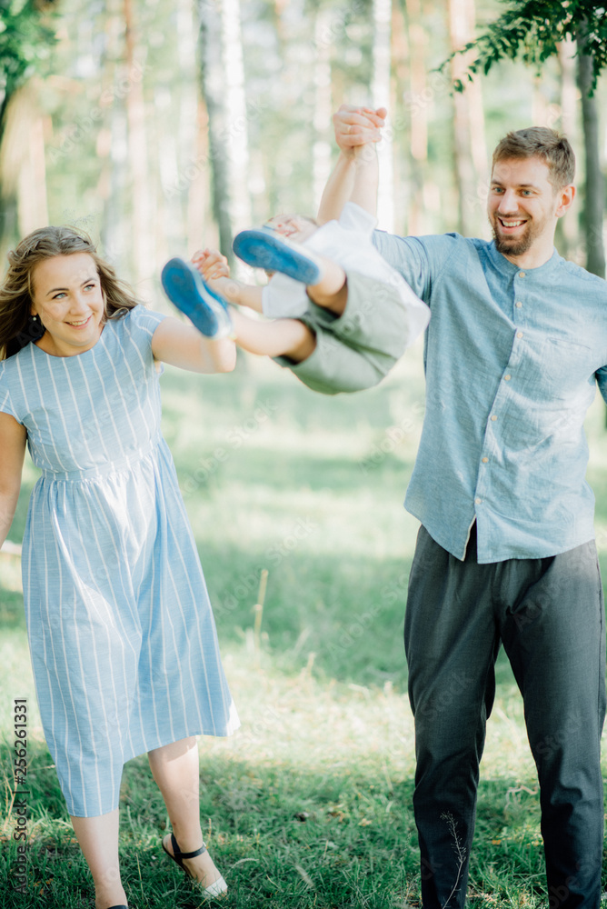 Happy young family spending time together outside in green nature