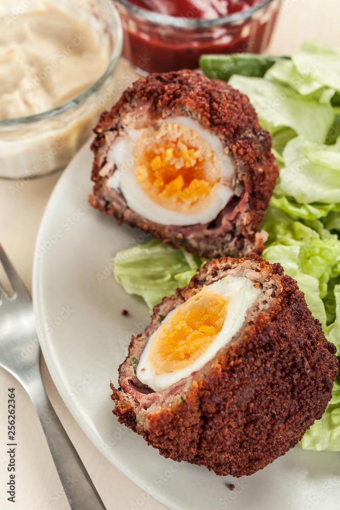 Scotch eggs cut in halves on a plate Scotch eggs cut in halves on a plate