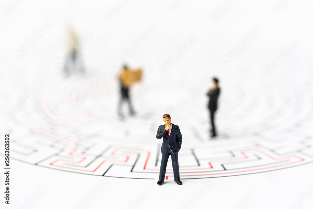 Miniature people, businessman in the labyrinth or maze figuring out the way out. Business concept, finding solution, strategic, and business opportunity. Miniature people, businessman in the labyrinth or maze figuring out the way out. Business concept, finding solution, strategic, and business opportunity.