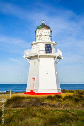 Travel New Zealand. Scenic view of white lighthouse on coast  ocean  outdoor background. Popular tourist attraction  Waipapa Point Lighthouse located at Southland  South Island. Travel concept.Catlins