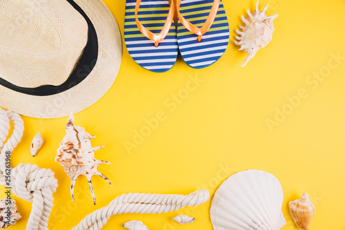 Summer concept. Travel accessories: a straw hat, a camera, a rope, shells and slippers.