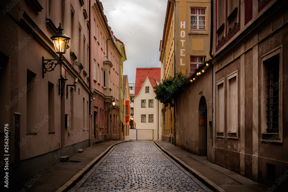 Dark, cobblestone covered street in the historic old town of Augsburg, a romantic medieval city in Bavaria, Germany