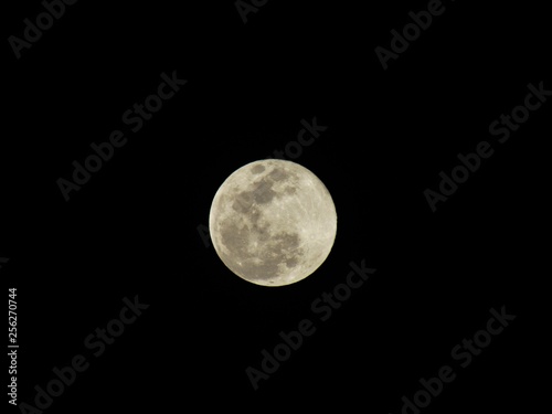 Beautiful bright full Moon in the night sky, lighting up all the colours below it photo