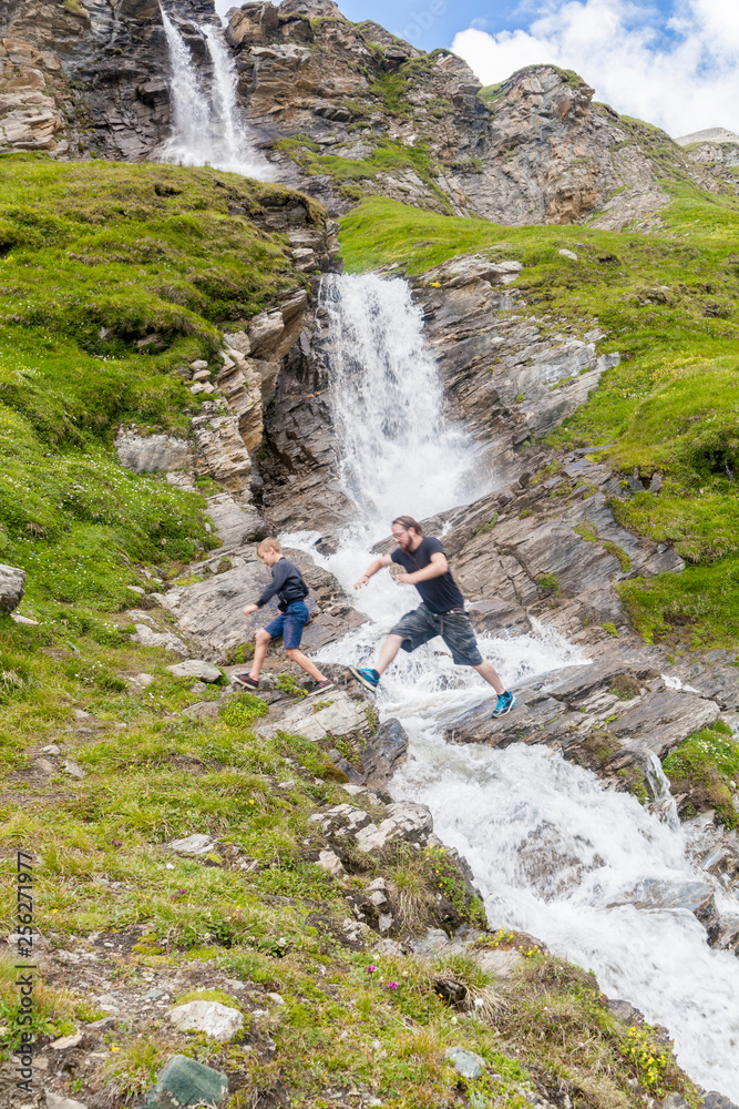 A father and son at the alpine waterfall