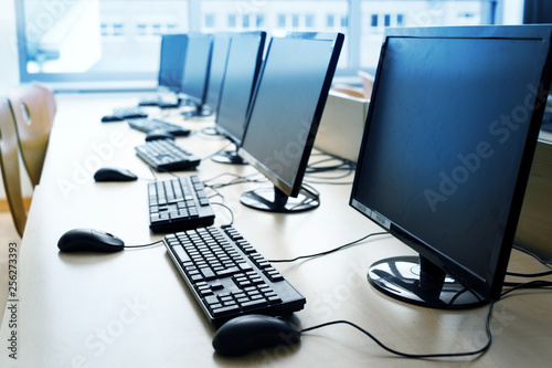 Pc computer workspaces in a row for creative workers, programmer or students in a computer lab, photo