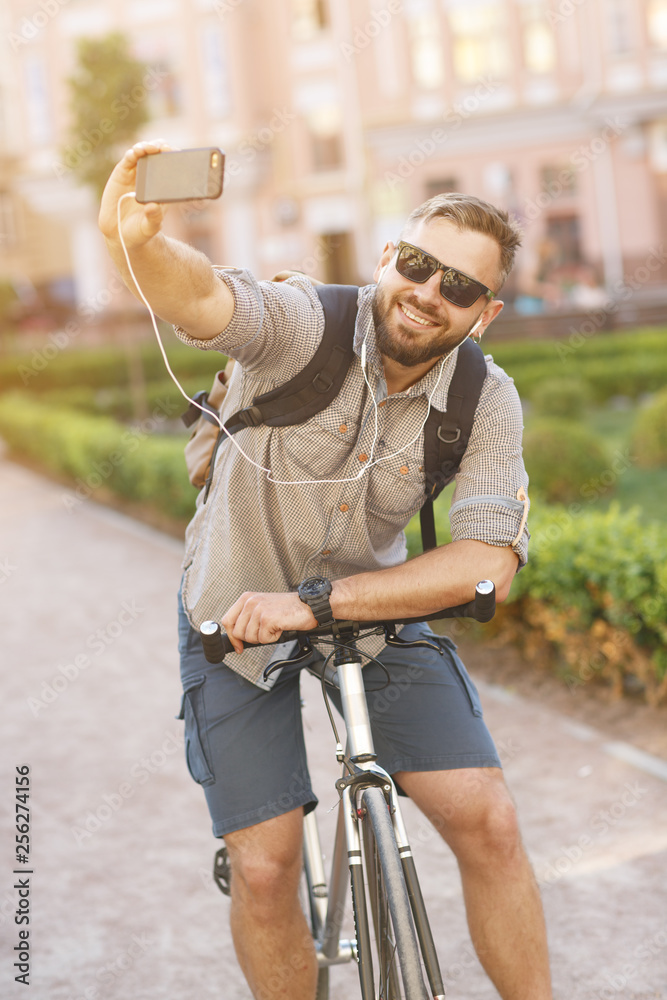 Naklejka premium Young handsome bearded man using his smart phone