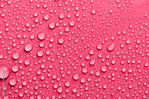 Red surface with clear water drops, background