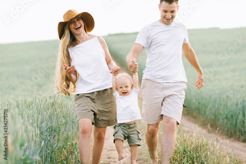 A young family have a fun with their little baby in the field