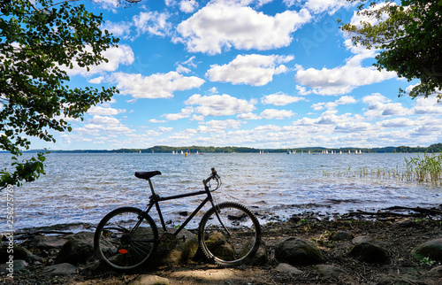 Bicycle at Schwerin lake with sailing yacht race in the background. Mecklenburg-Vorpommern, Germany