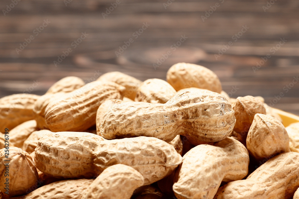Рeanuts close up on wooden background. Place for text. Top view. Рeanuts close up on wooden background. Place for text. Top view.