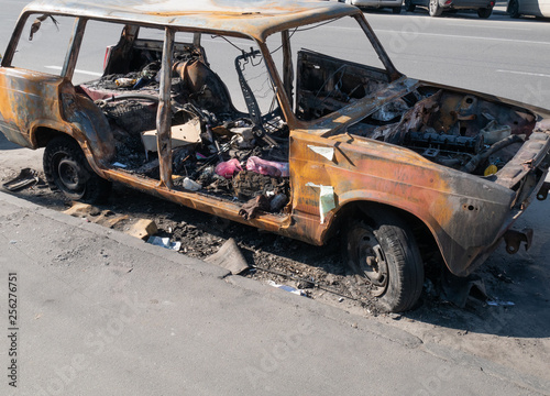 abandoned burned old car auto after riot on street transformed into trashcan. depict vehicle insurance service